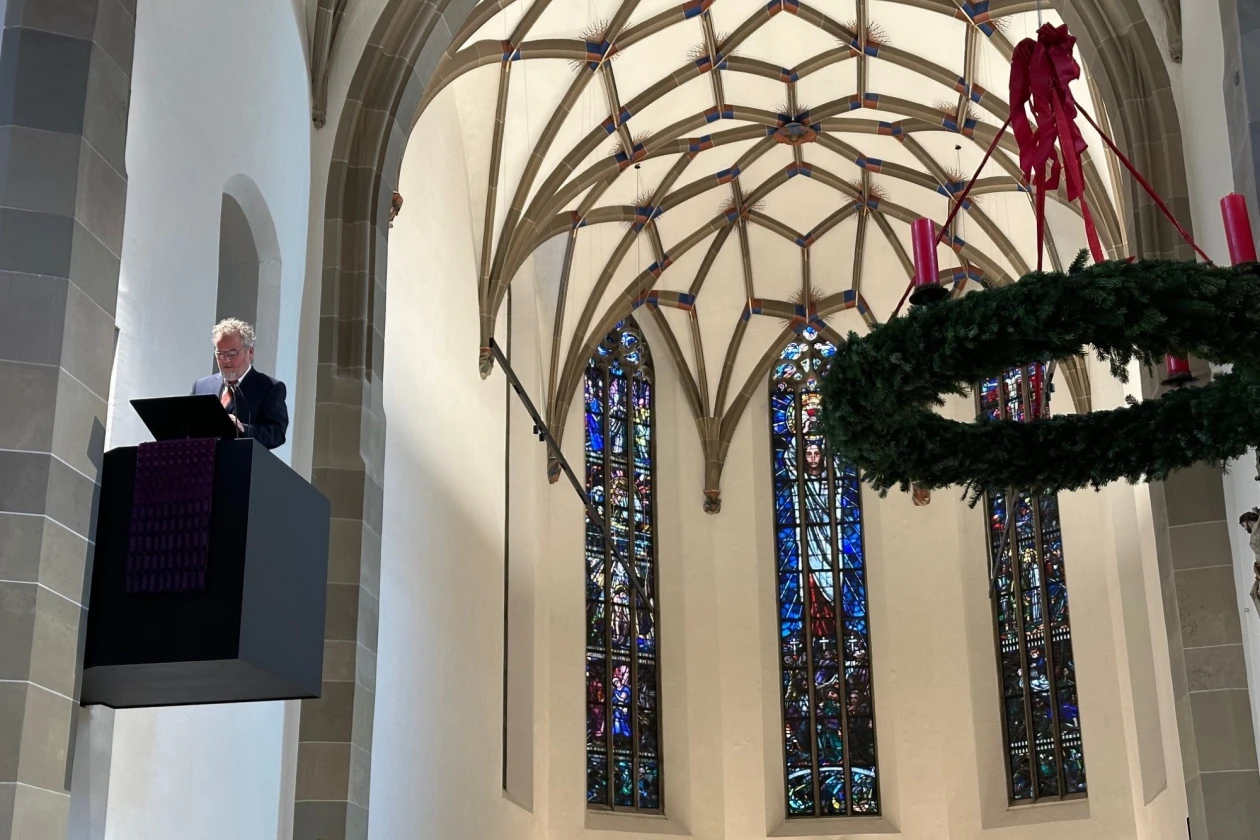 Ein &auml;lterer Mann steht in einer Kirche auf der Kanzel.