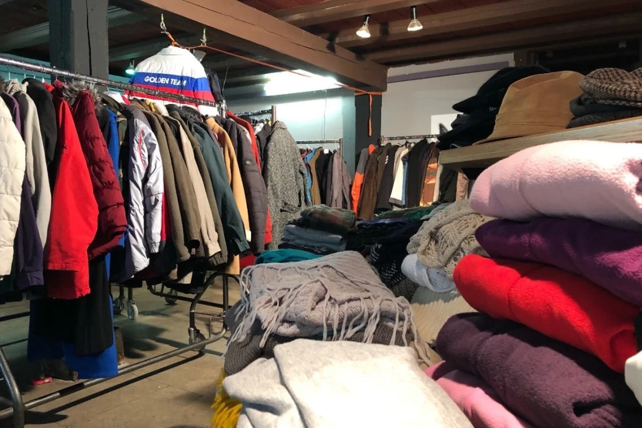 Ein Raum mit vollen Kleiderst&auml;ndern und Stapeln mit Pullover und Schals.