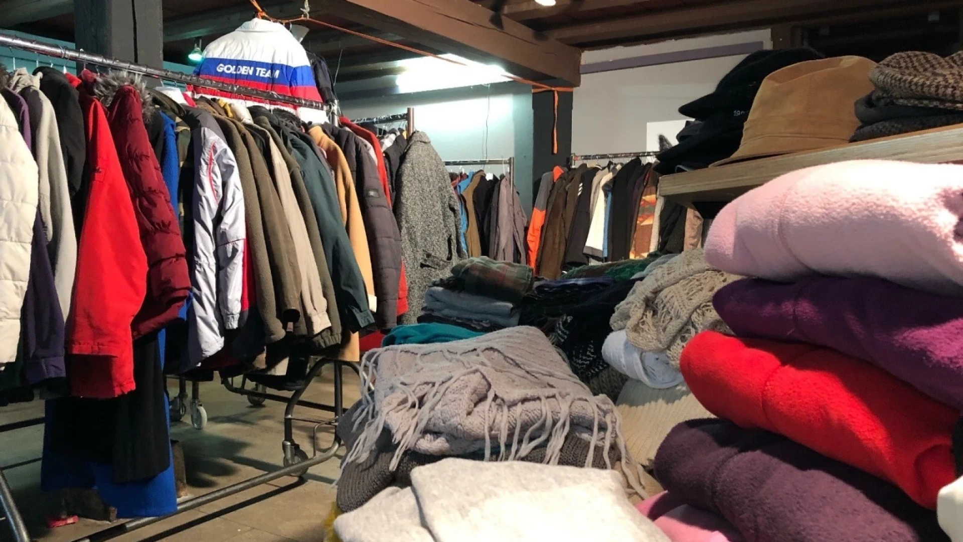 Ein Raum mit vollen Kleiderst&auml;ndern und Stapeln mit Pullover und Schals.