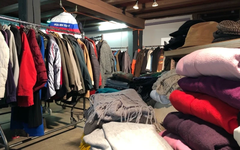 Ein Raum mit vollen Kleiderst&auml;ndern und Stapeln mit Pullover und Schals.