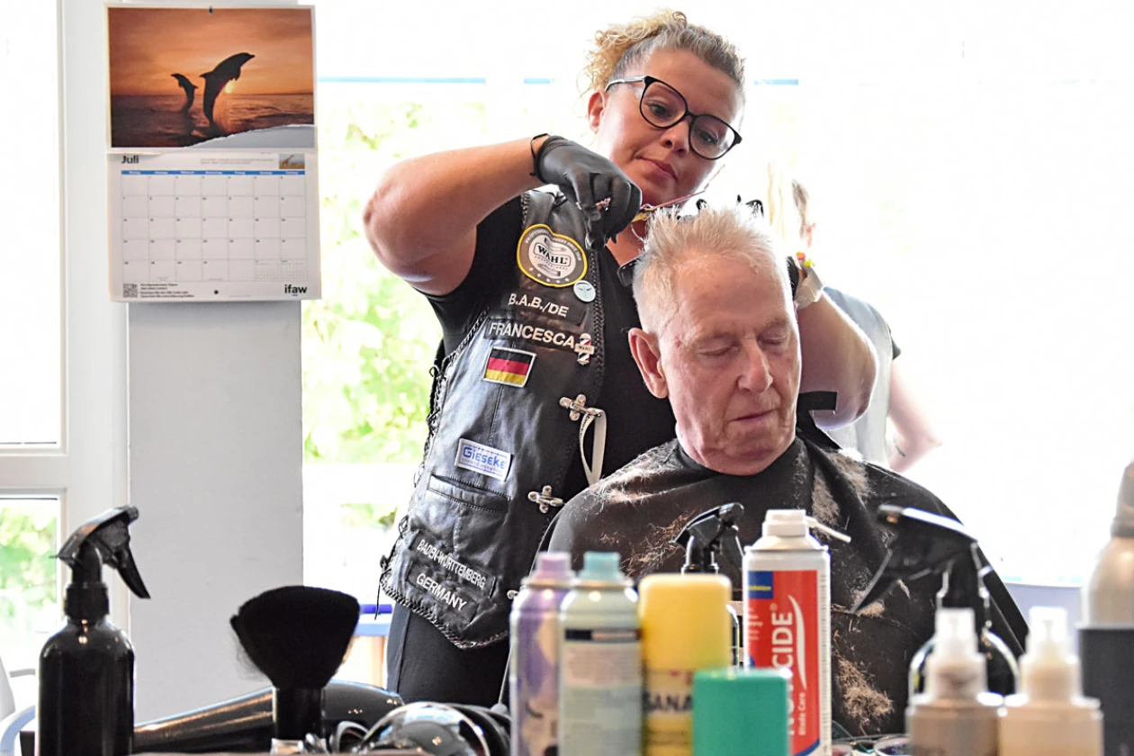 Eine Friseurin schneidet einem Mann die Haare in einem hellen Salon