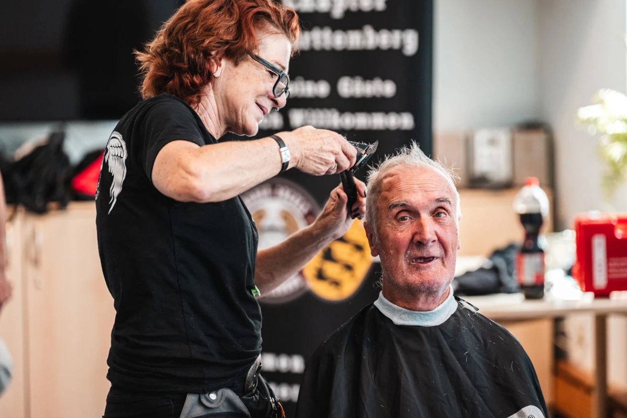 Eine Friseurin schneidet einem &auml;lteren Mann die Haare