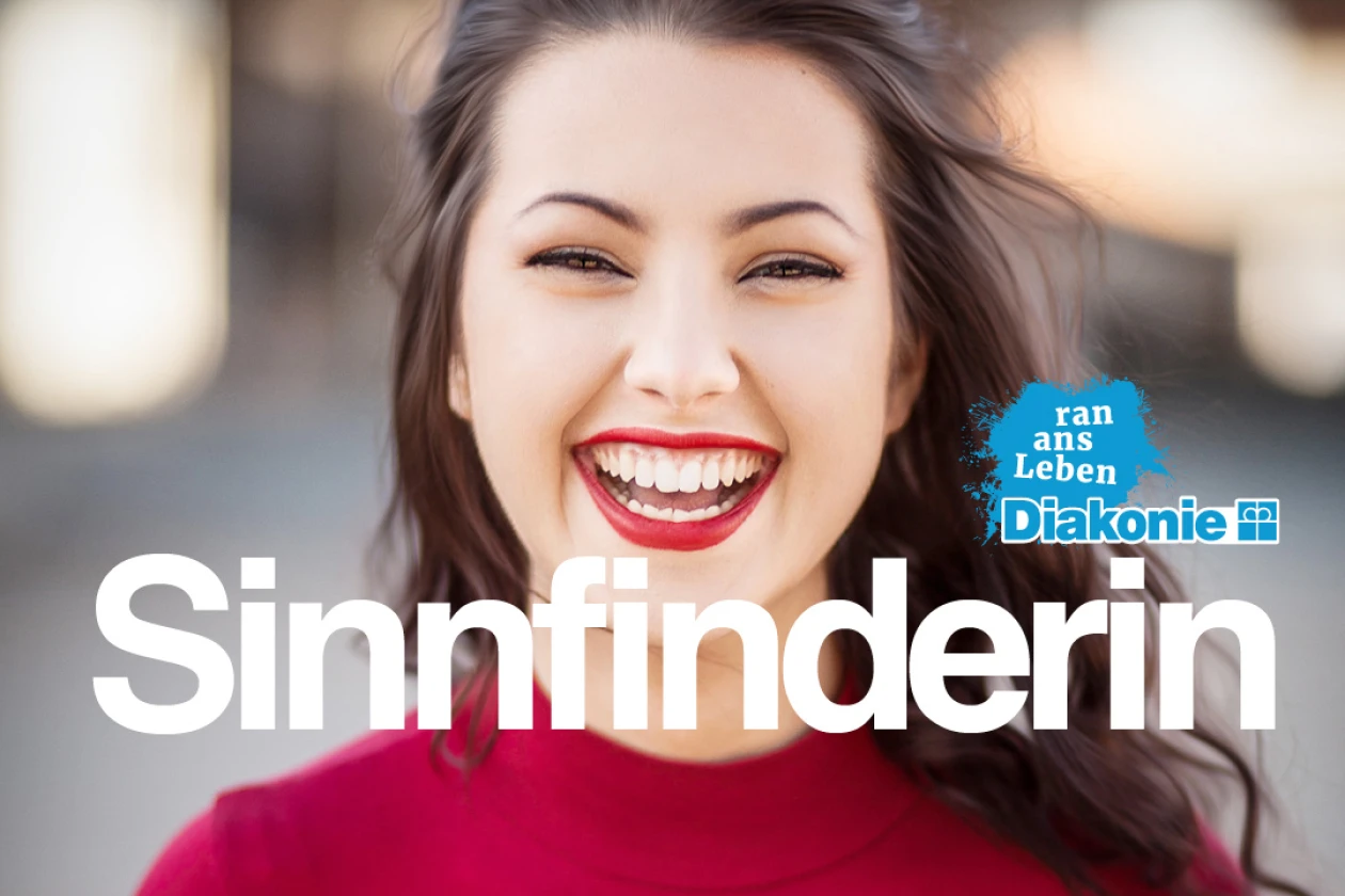 L&auml;chelnde junge Frau in rotem Oberteil mit gro&szlig;em Schriftzug "Sinnfinderin". Werbeplakat der Diakonie f&uuml;r FSJ, Praktikum und duales Studium mit blauem Diakonie-Logo.