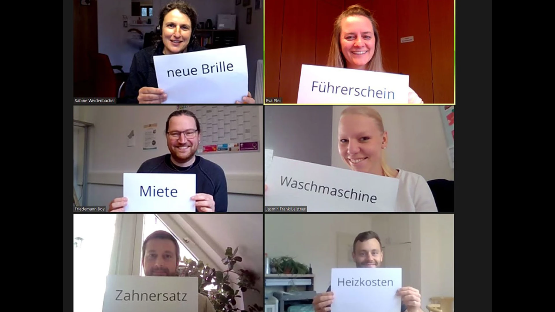 Sechs Personen in einer Videokonferenz. Sie halten Schilder mit einem Worten "neue Brille", "F&uuml;hrerschein", "Miete", "Waschmaschine", "Zahnersatz" und "Heizkosten" in die Kamera und l&auml;cheln dabei.