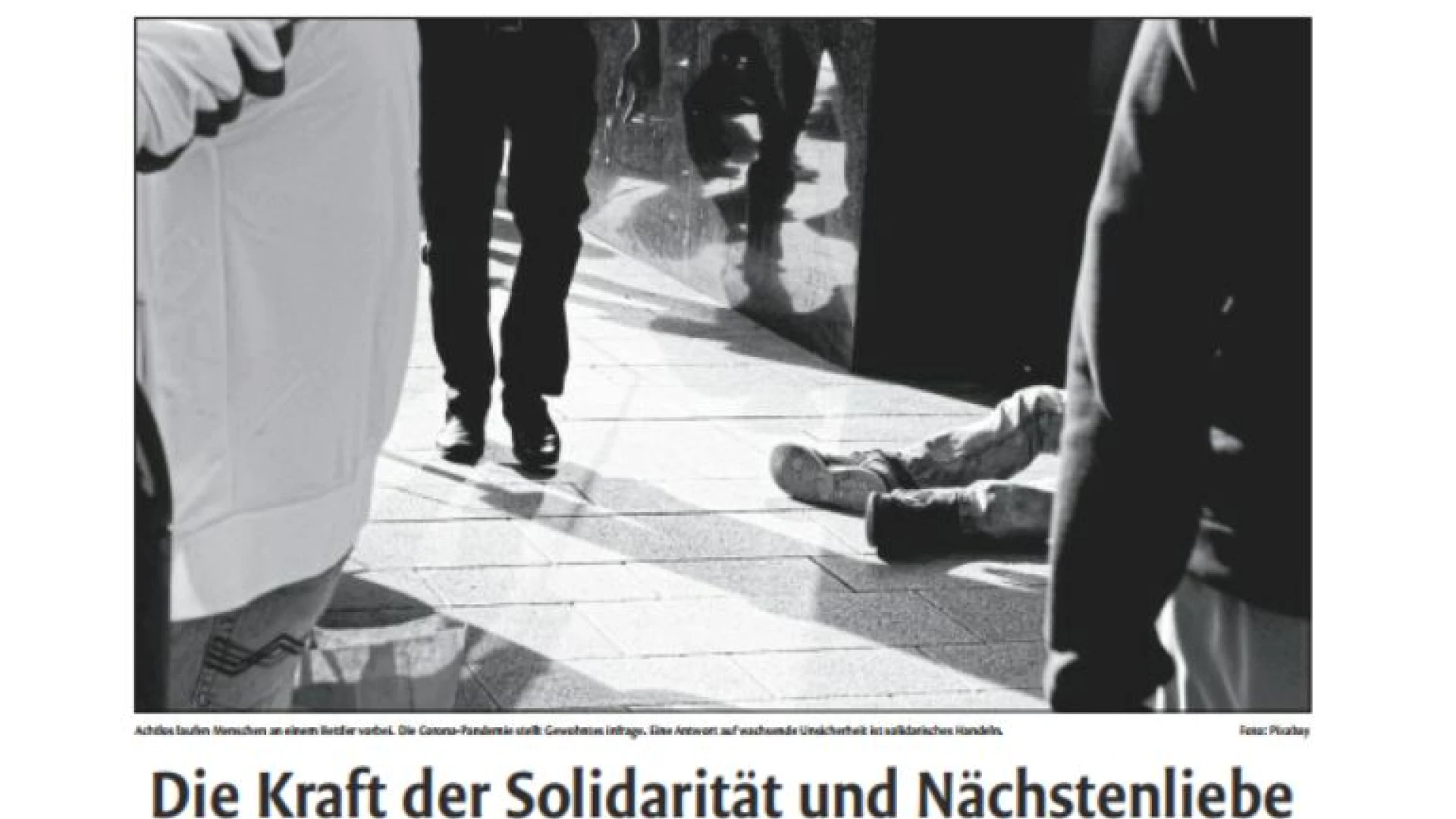 Schwarzwei&szlig;fotografie von Beinen und einer am Boden liegenden Person, die eine soziale Notsituation auf der Stra&szlig;e andeutet, mit &Uuml;berschrift: "Die Kraft der Solidarit&auml;t und N&auml;chstenliebe.