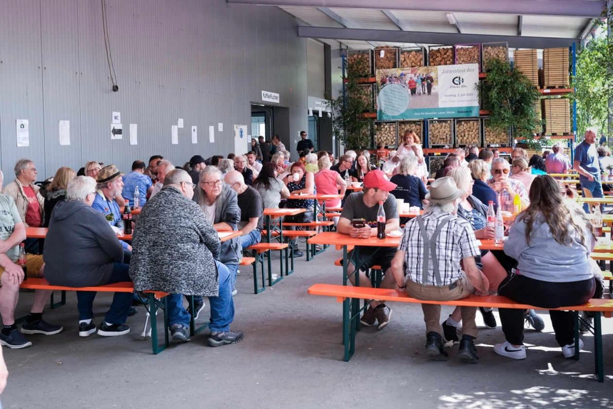 Festbetrieb mit Menschen auf Biertischb&auml;nken in gem&uuml;tlicher Festatmosph&auml;re.