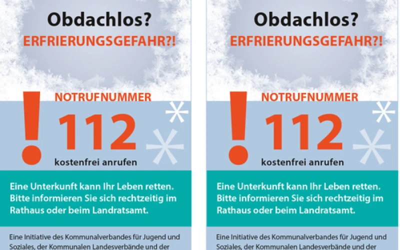 Zwei identische Plakate zur K&auml;ltehilfe mit der &Uuml;berschrift "Obdachlos? ERFRIERGUNGSGEFAHR?!" zeigen die Notrufnummer 112 in gro&szlig;en roten Ziffern und informieren, dass Unterkunft Leben retten kann