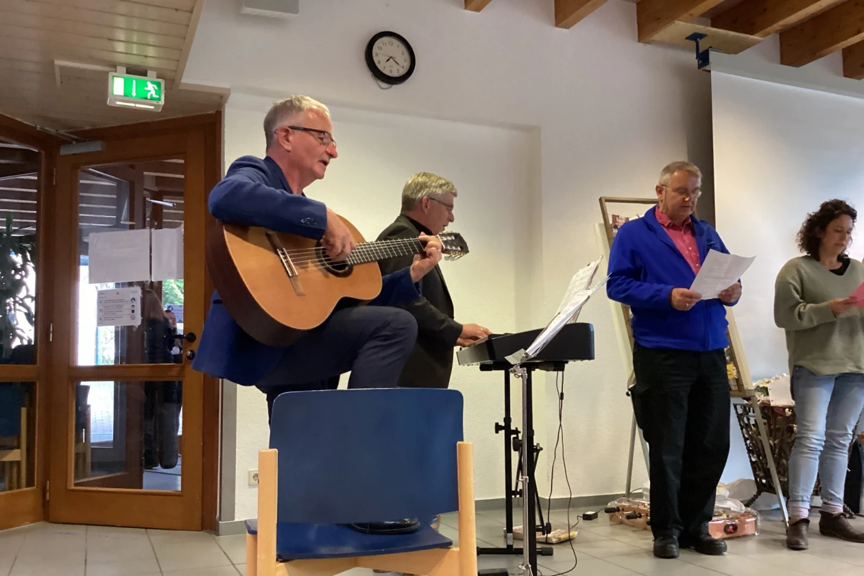 Zu sehen sind drei M&auml;nner und eine Frau. Ein Mann spielt Gitarre, einer E-Piano, der dritte Mann und die Frau singen.