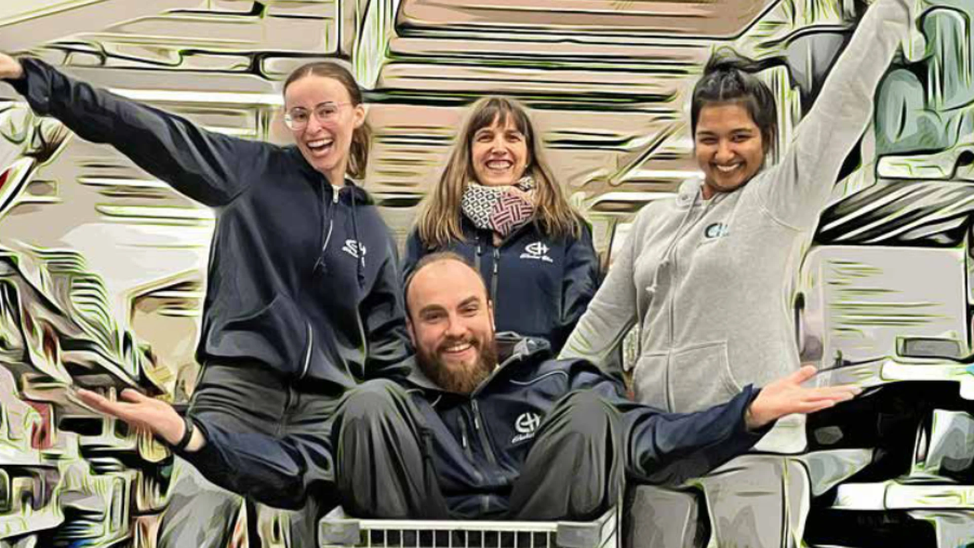 Vier Personen strahlen in die Kamera. Sie strecken die Arme zu einer herzlichen Begr&uuml;&szlig;ung aus und sitzen bzw. stehen nebeneinander vor einem abstrakten, skizzierten Hintergrund.