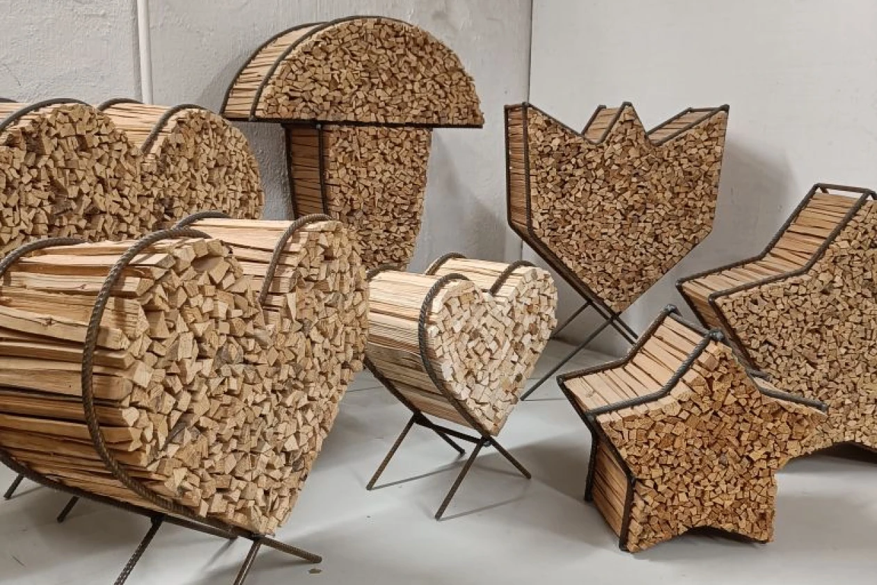 Verschiedene dekorative Metallgestelle mit Anz&uuml;ndholz in unterschiedlichen Formen wie Pilz, Herz, Stern und Tulpe stehen vor einer wei&szlig;en Wand.