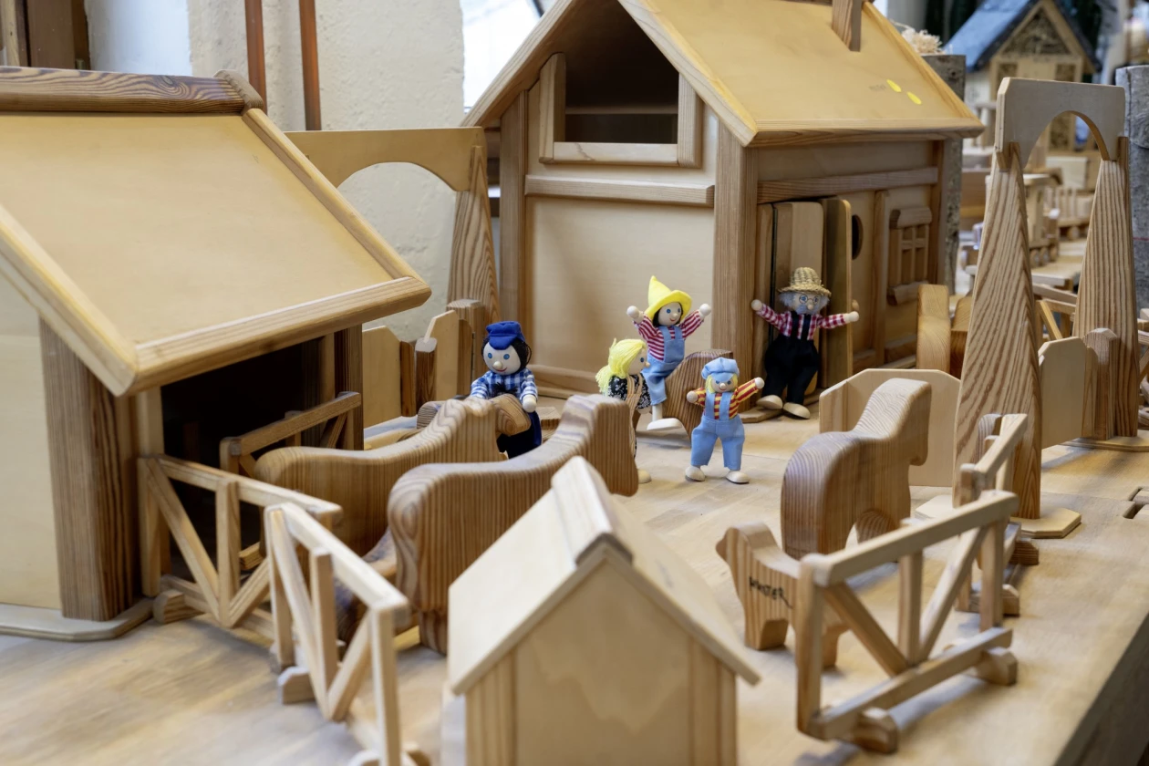 Zu sehen ist eine Holzbauernhof mit mehreren Geb&auml;uden, Tieren und kleinen Figuren.