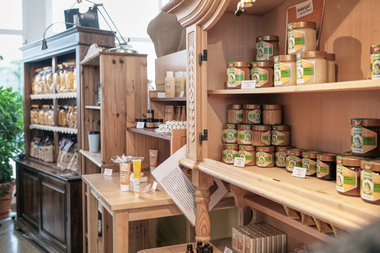 Holzbuffets und Holzregale mit verschiedenen Lebensmitteln wie Honig und Nudeln, sorgsam angeordnet in rustikaler, einladender Atmosph&auml;re.