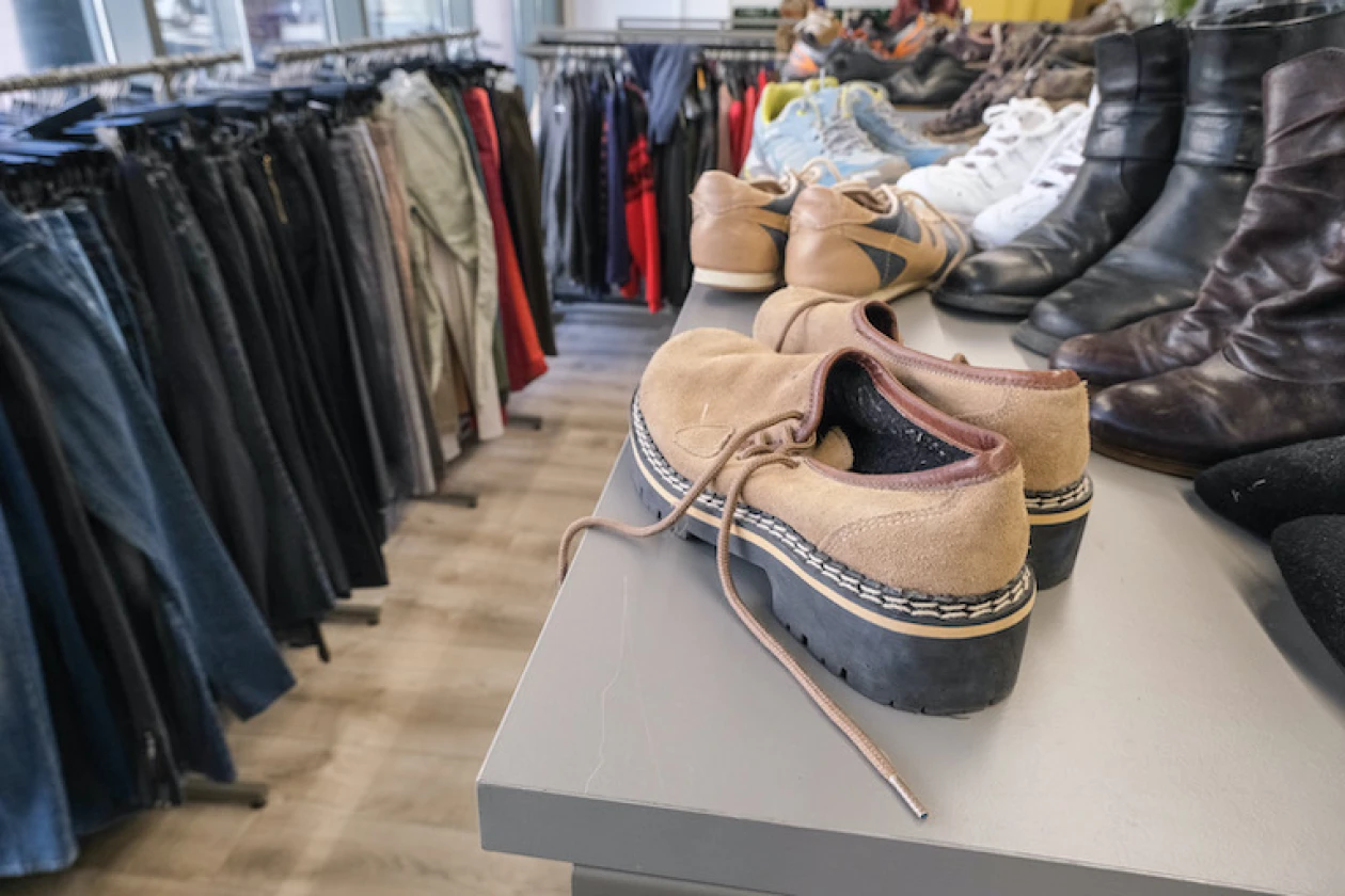 Ein Raum voller Kleidung er&ouml;ffnet den Blick auf eine vielf&auml;ltige Auswahl an Schuhen, Hosen und Pullovern in unterschiedlichen Farben.