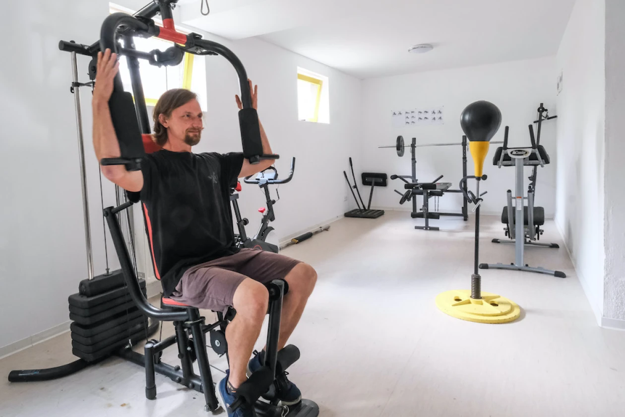 Ein Mann trainiert in einem Raum mit Fitnessger&auml;ten.